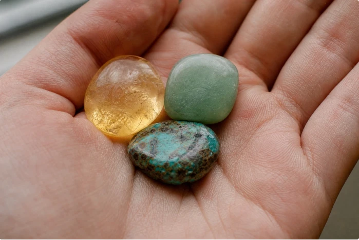 Une citrine, une aventurine verte et une turquoise africaine dans une paume